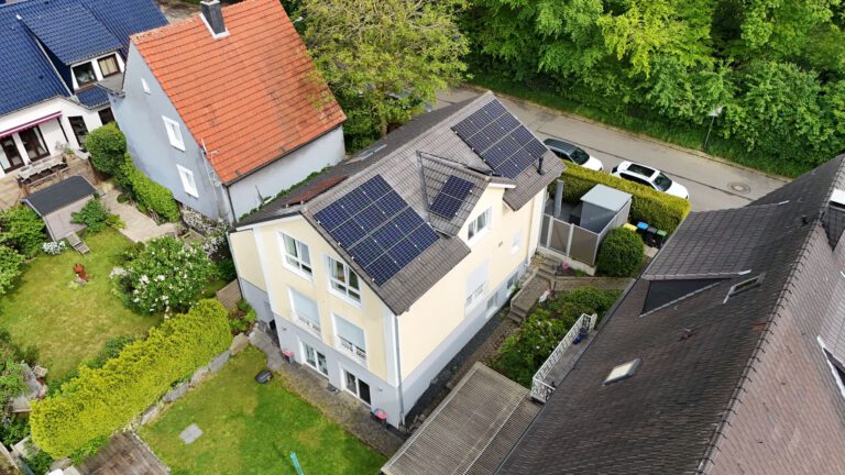 Luftaufnahme einer Photovoltaikanlage, die auf dem Dach eines Gebäudes montiert ist