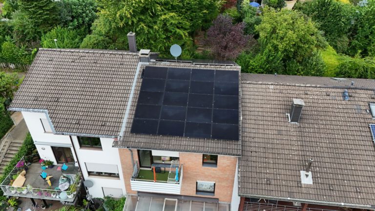 Luftaufnahme einer Photovoltaikanlage, die auf dem Dach eines Gebäudes montiert ist