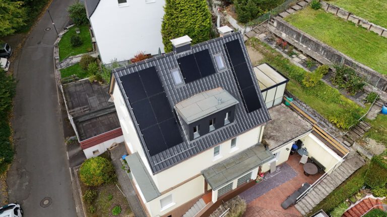 Luftaufnahme einer Photovoltaikanlage, die auf dem Dach eines Gebäudes montiert ist
