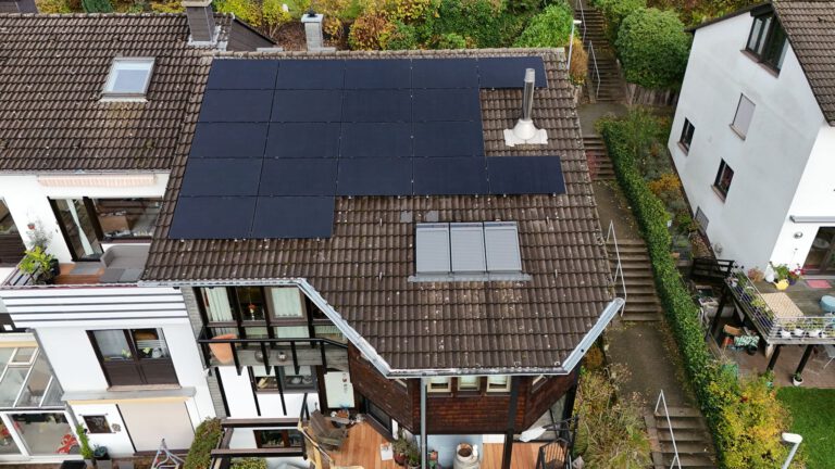 Luftaufnahme einer Photovoltaikanlage, die auf dem Dach eines Gebäudes montiert ist