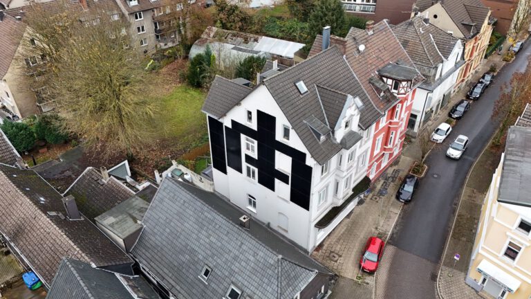 Luftaufnahme einer Photovoltaikanlage, die an der Stirnseite eines Gebäudes montiert ist