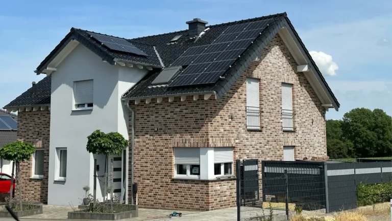 Ansicht eines Hauses mit auf dem Dach montierter Photovoltaikanlage