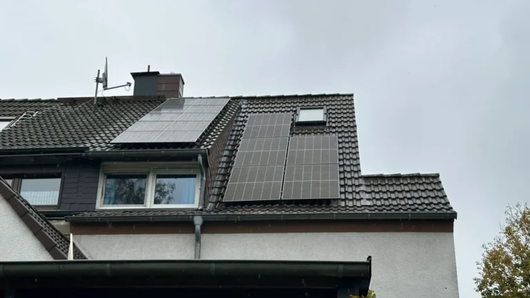 Aufnahme einer auf einem Dach montierter Photovoltaikanlage von der Straße aus gesehen