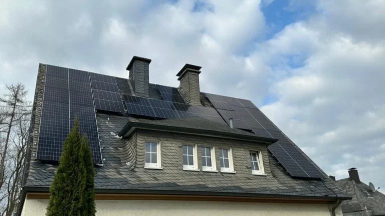 Aufnahme einer Photovoltaikanlage, die auf dem Dach eines Gebäudes montiert ist, von unten aus gesehen