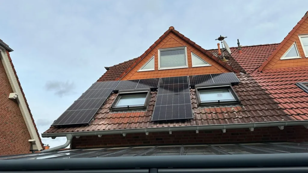 Aufnahme einer Photovoltaikanlage, die auf dem Dach eines Gebäudes montiert ist, von unten aus gesehen