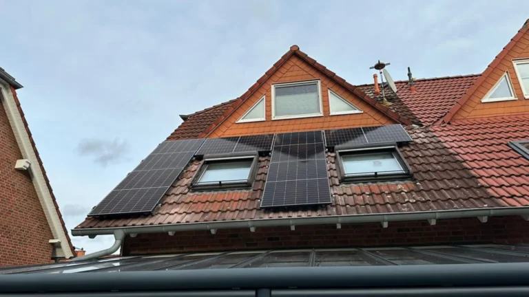 Aufnahme einer Photovoltaikanlage, die auf dem Dach eines Gebäudes montiert ist, von unten aus gesehen