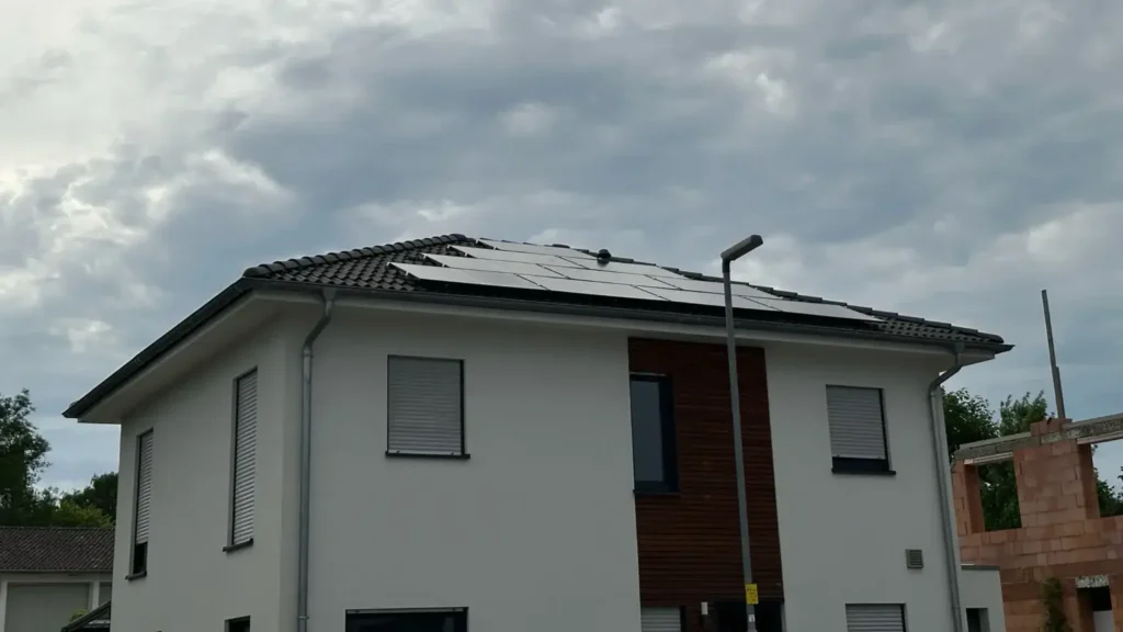 Aufnahme einer Photovoltaikanlage, die auf dem Dach eines Gebäudes montiert ist, von unten aus gesehen