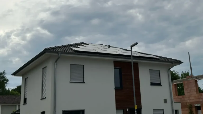 Aufnahme einer Photovoltaikanlage, die auf dem Dach eines Gebäudes montiert ist, von unten aus gesehen