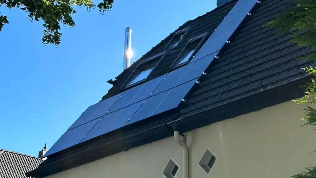 Aufnahme einer Photovoltaikanlage, die auf dem Dach eines Gebäudes montiert ist, von unten aus gesehen