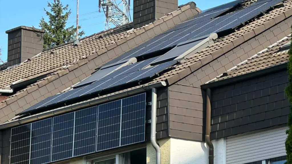 Aufnahme einer Photovoltaikanlage, die auf dem Dach eines Gebäudes montiert ist, von unten aus gesehen