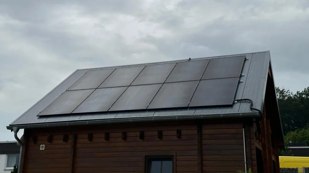 Aufnahme einer Photovoltaikanlage, die auf dem Dach eines Gebäudes montiert ist, von unten aus gesehen