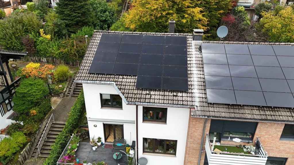 Luftaufnahme mittels Drohne einer auf einem Dach montierter Photovoltaikanlage