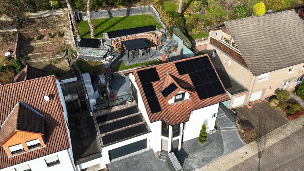 Luftaufnahme mittels Drohne einer auf einem Dach montierter Photovoltaikanlage