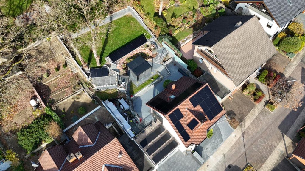 Luftaufnahme mittels Drohne einer auf einem Dach montierter Photovoltaikanlage