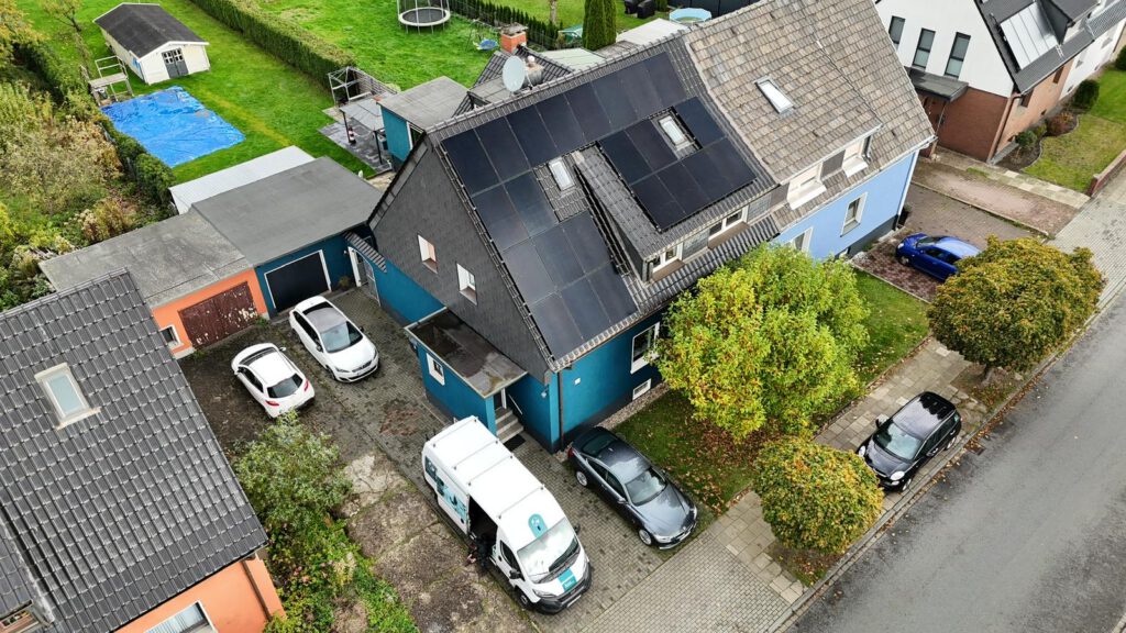 Luftaufnahme mittels Drohne einer auf einem Dach montierter Photovoltaikanlage