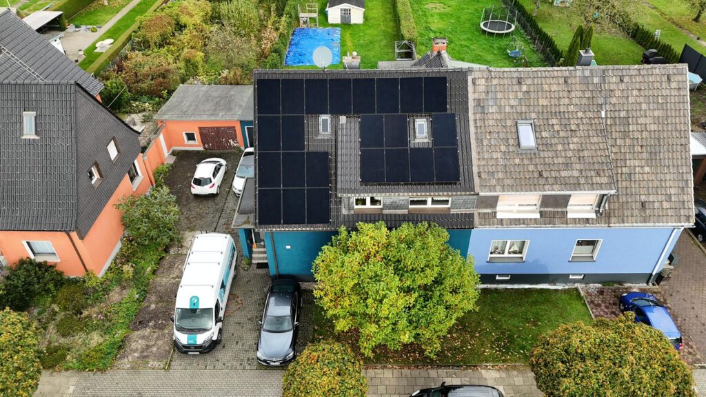 Luftaufnahme mittels Drohne einer auf einem Dach montierter Photovoltaikanlage