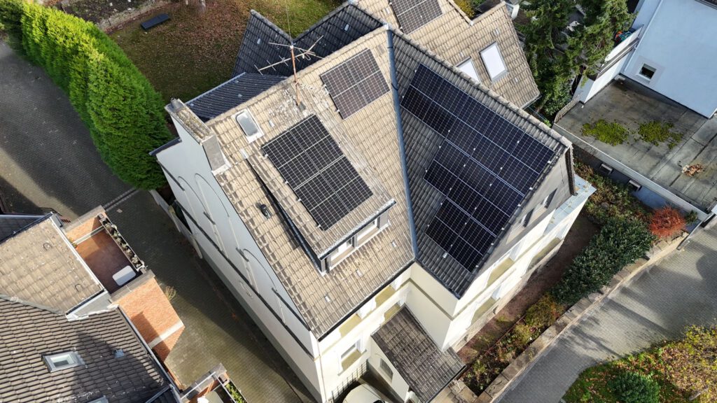Luftaufnahme mittels Drohne einer auf einem Dach montierter Photovoltaikanlage