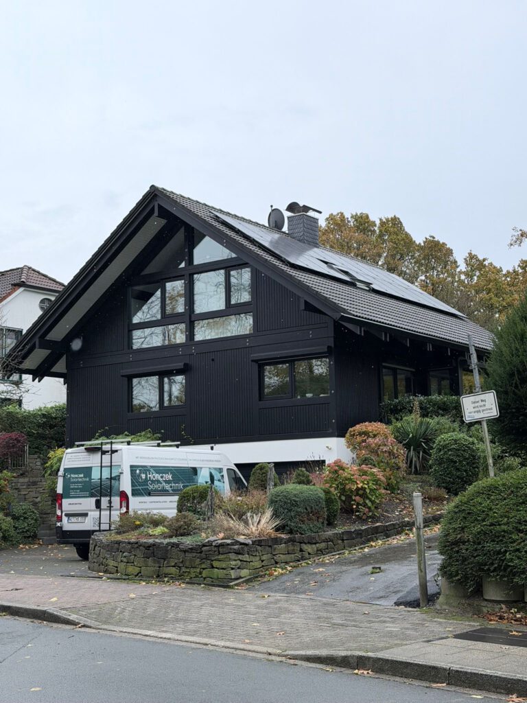 Aufnahme einer Photovoltaikanlage, die auf dem Dach eines Gebäudes montiert ist, von unten aus gesehen