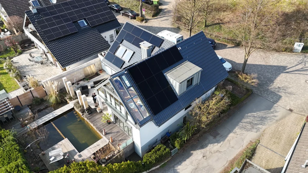 Luftaufnahme mittels Drohne einer auf einem Dach montierter Photovoltaikanlage