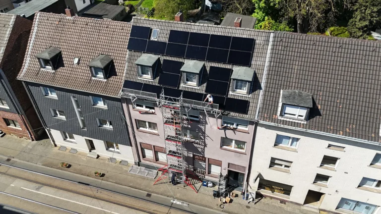 Drohnen-Aufnahme der Solar-Anlage auf dem Dach des mehrstöckigen Mietshauses