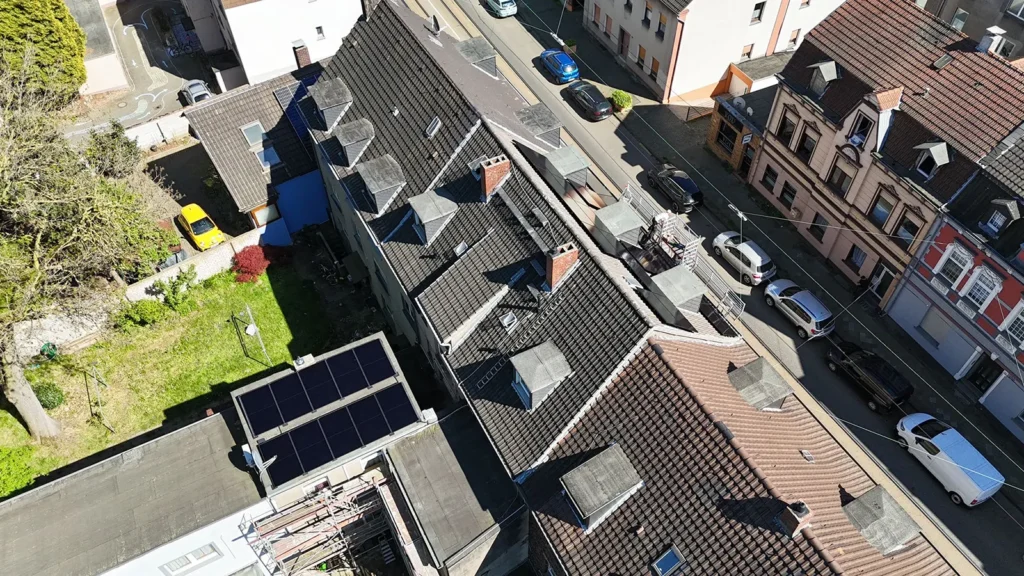Drohnen-Aufnahme der Solar-Anlage auf dem Dach des mehrstöckigen Mietshauses